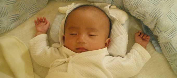 バンザイして寝る赤ちゃん